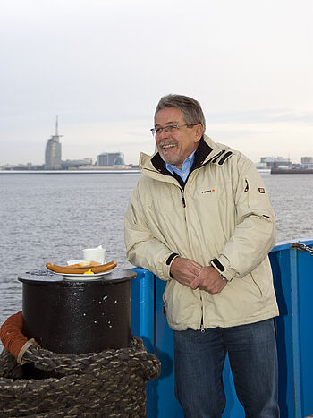 Ein Mann bei der Überfahrt mit einer der Fähren mit Bremerhaven im Hintergrund